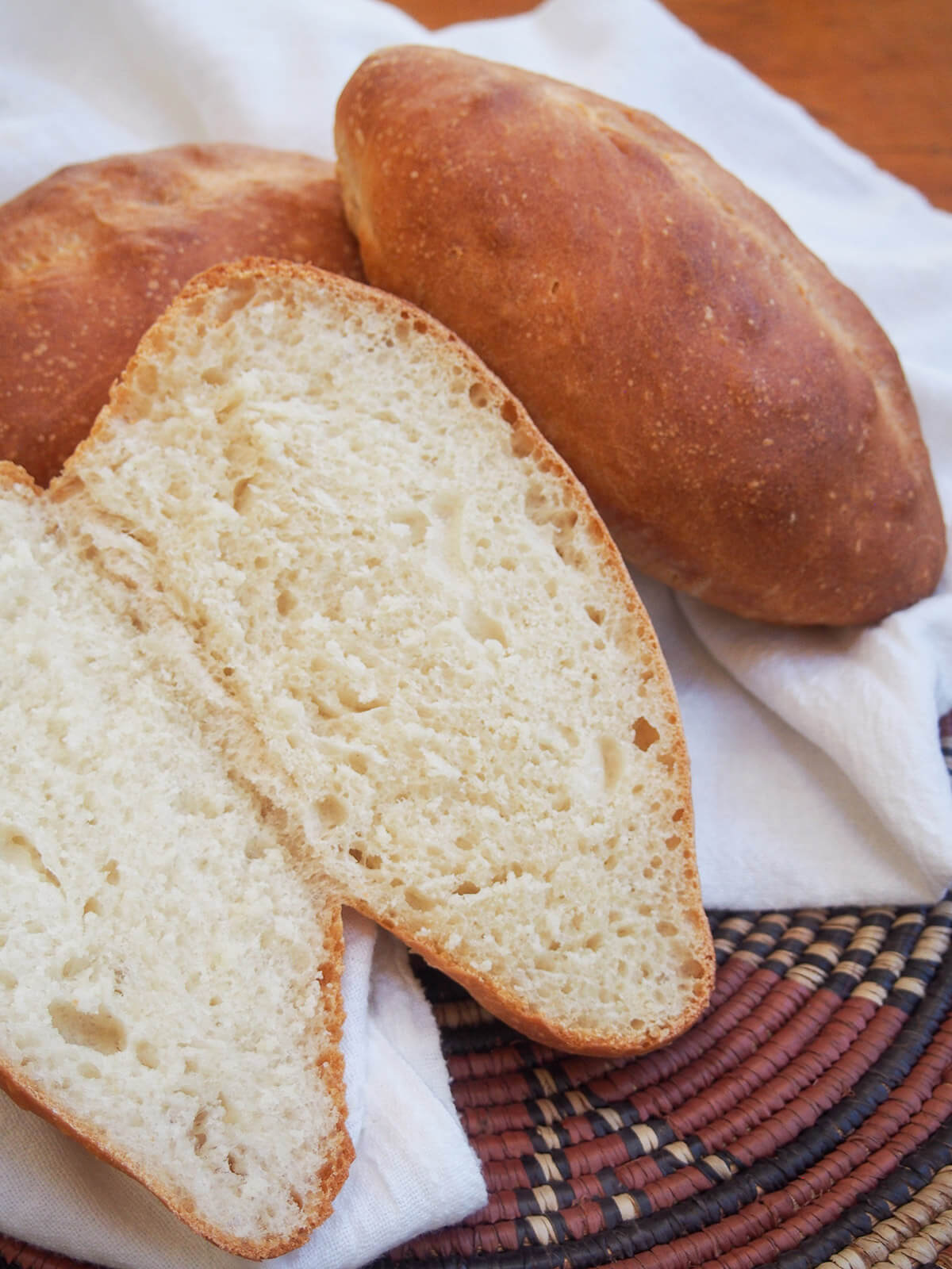 a bolillo bread roll cut open resting on another