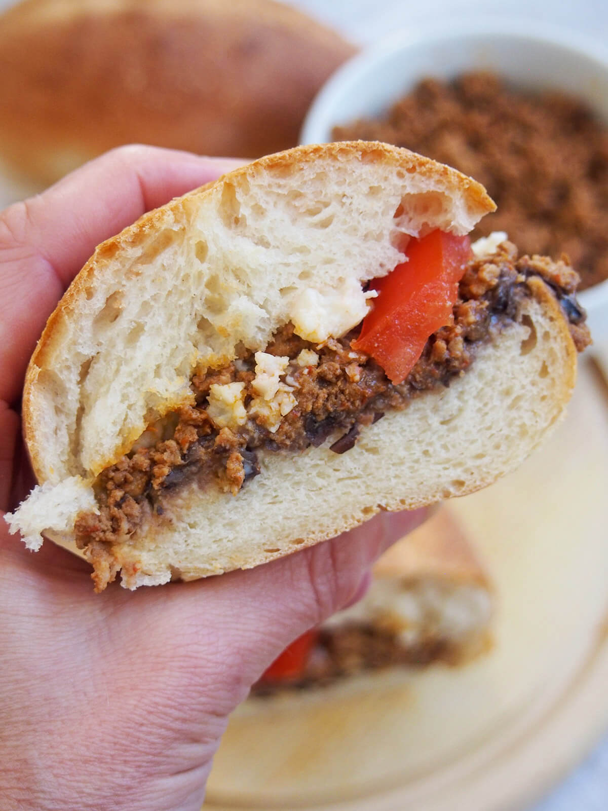 holding a half chorizo torta in hand