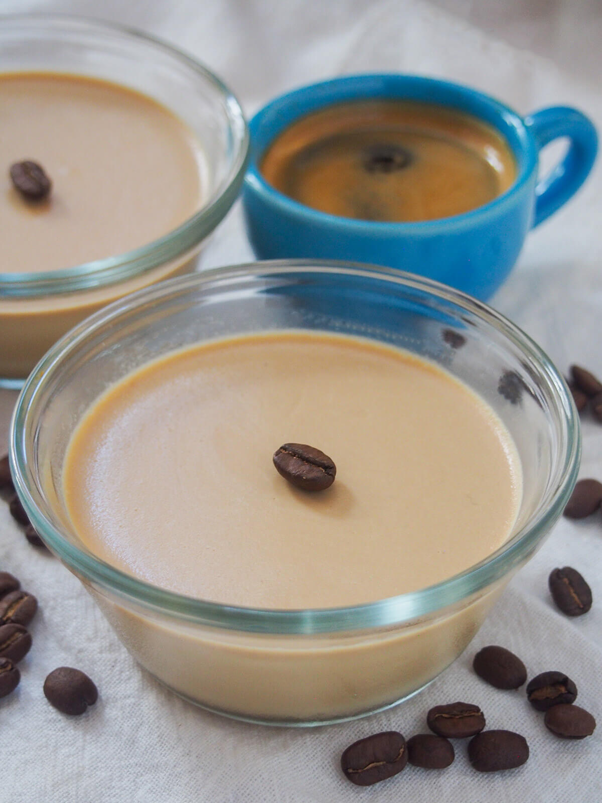 dish of coffee panna cotta with blue espresso cup and part of another dish behind