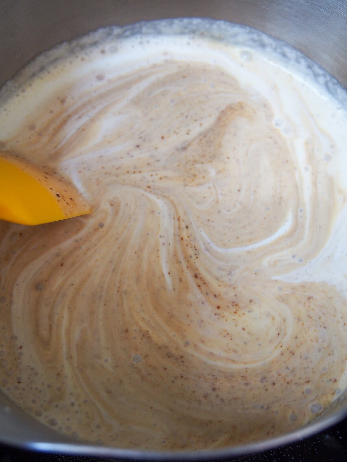 stirring cream and coconut sugar mixture in pan