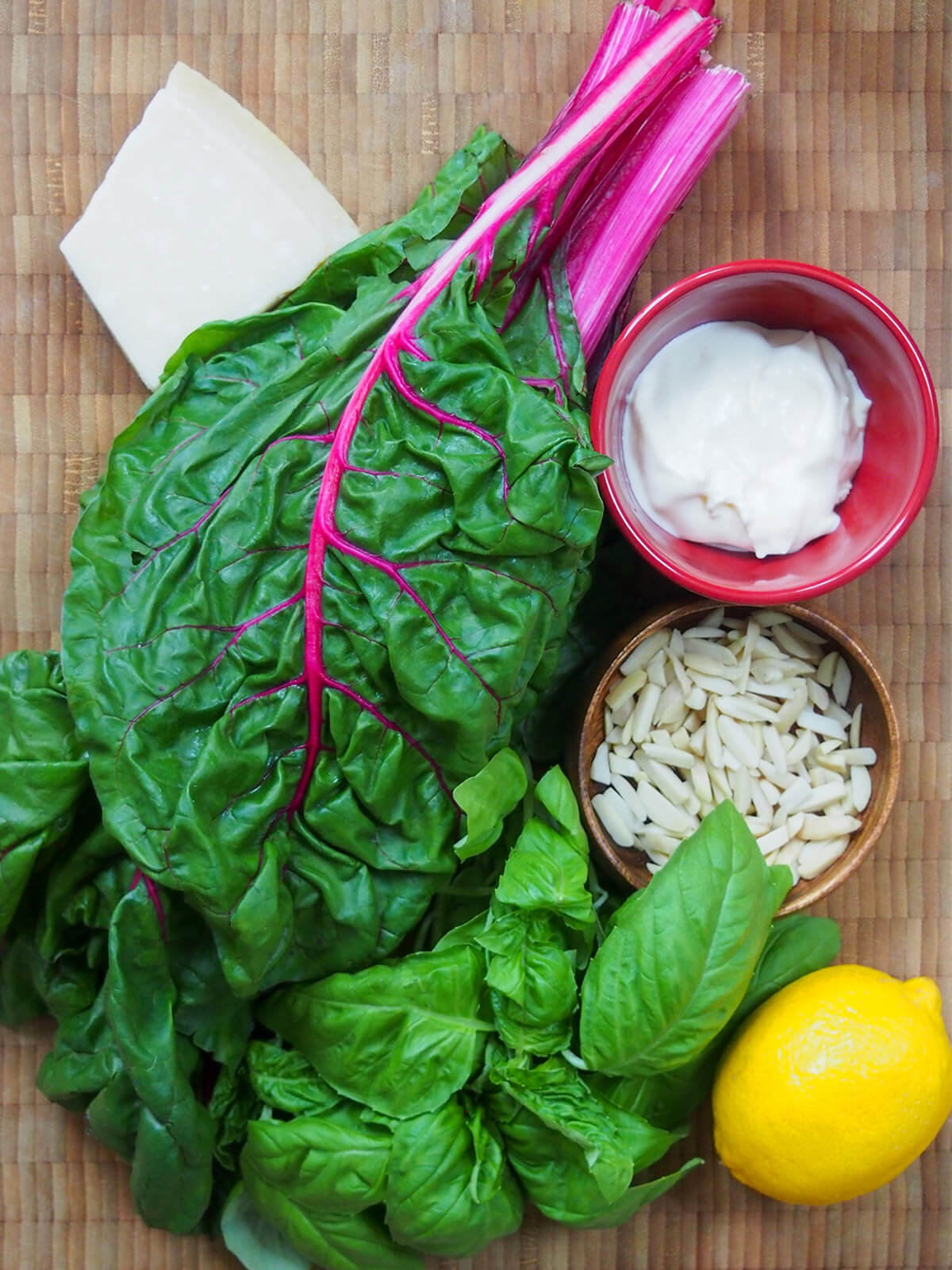 board with chard, basil, lemon, cheese and bowls with creme fraiche and almonds