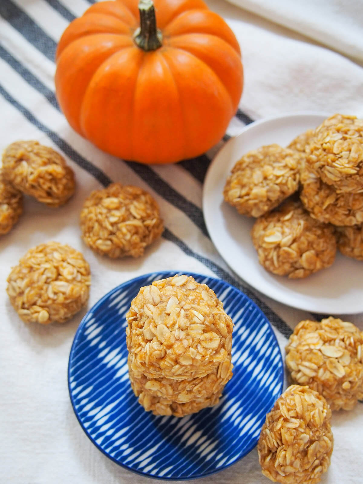 overhead view of stack of no bake pumpkin cookies with more cookies around and pumpkin above