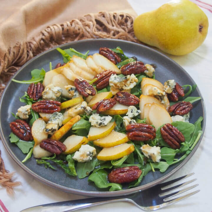 plate of pear gorgonzola salad with pear behind