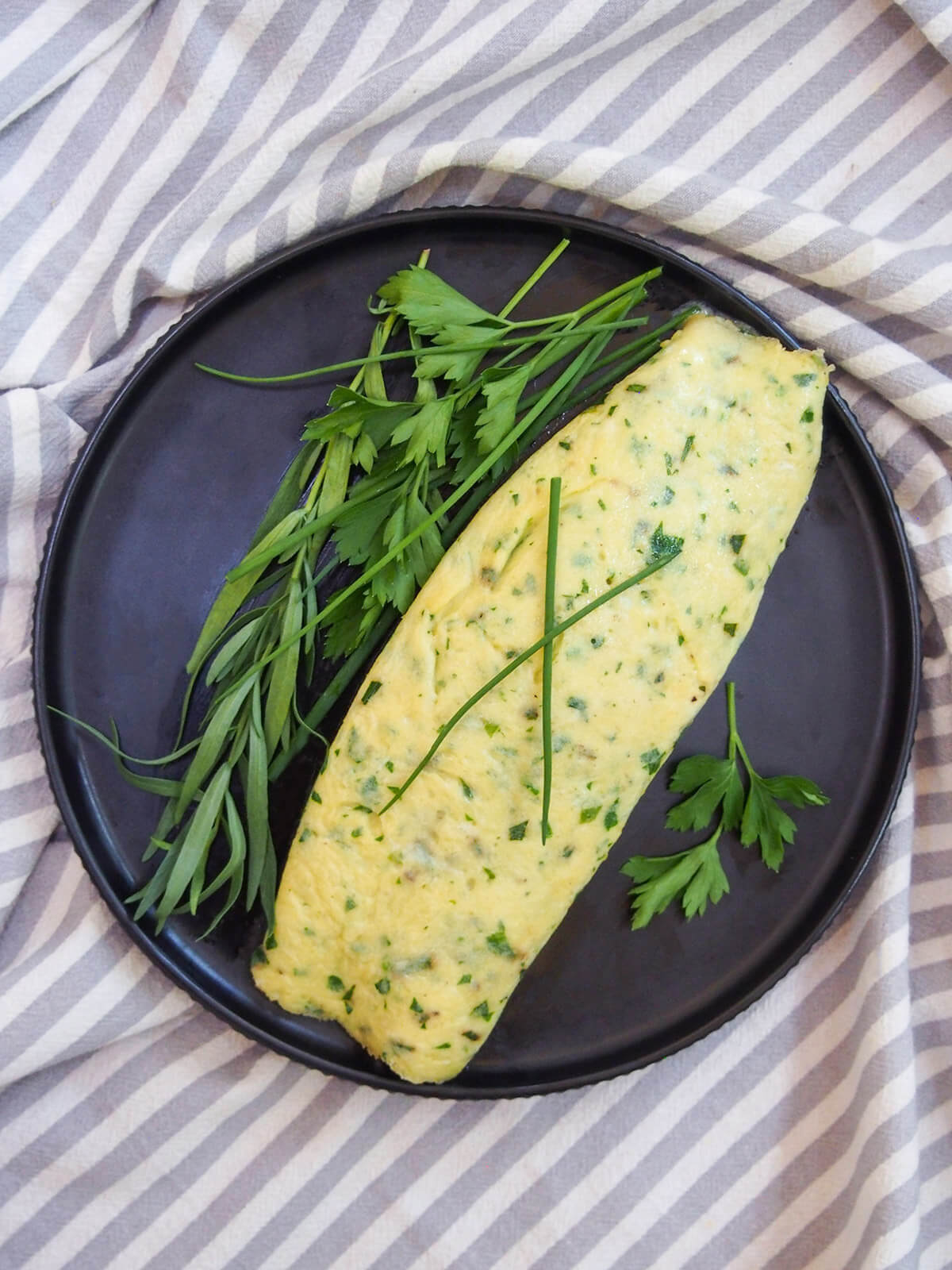 French omelette with herbs from overhead with herbs to side