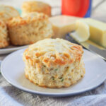 a cheese scone on a plate with more scones behind