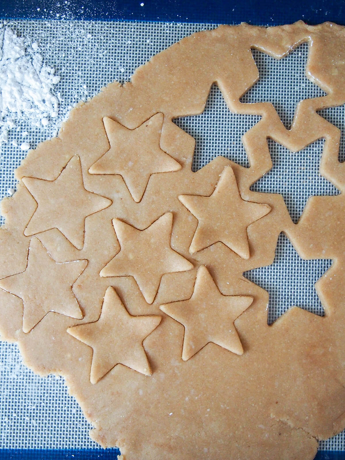 part way throguh cutting out star shapes from rolled out cookie dough