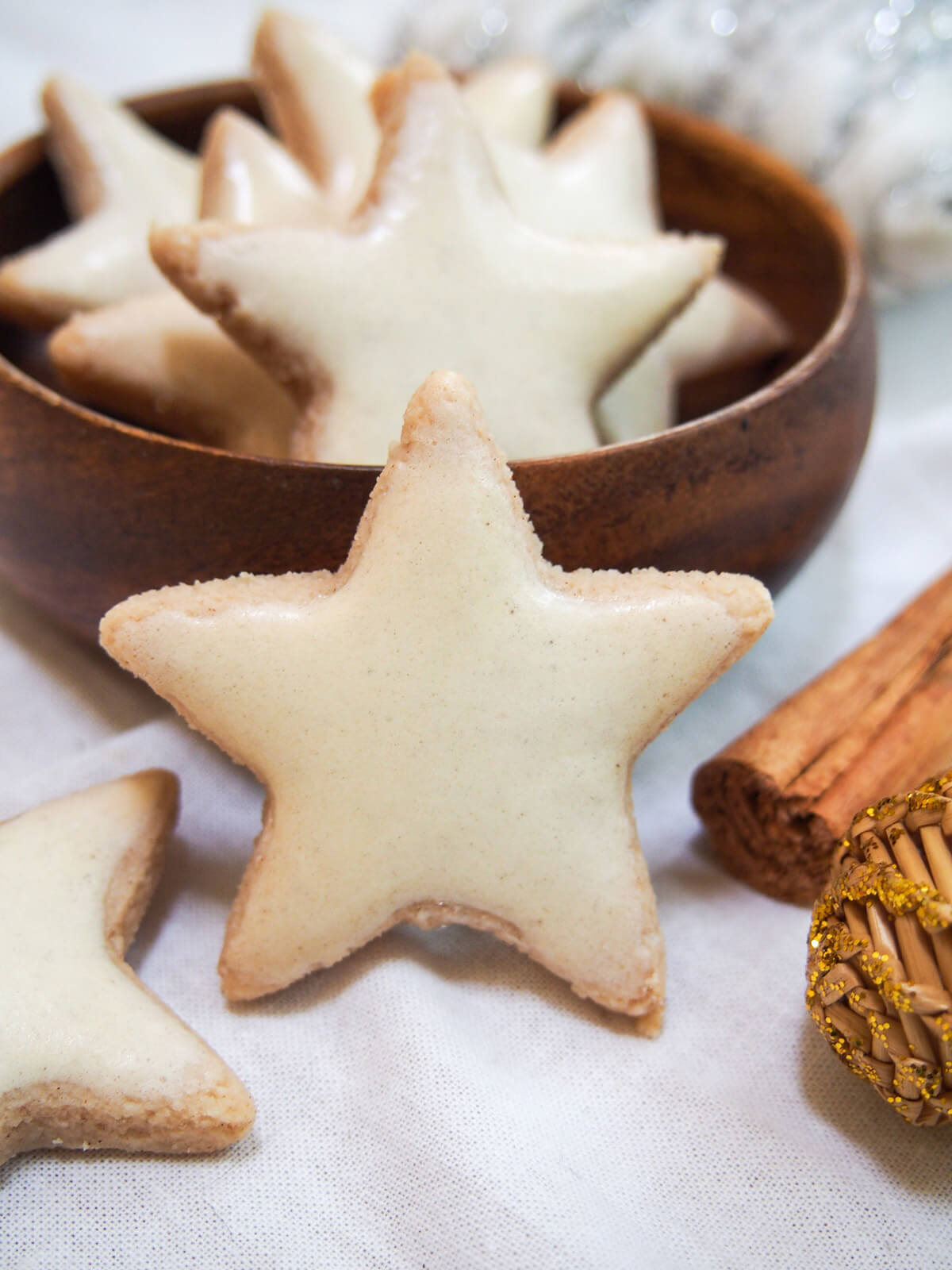 zimtsterne cinnamon star cookie resting against bowl with others in bowl
