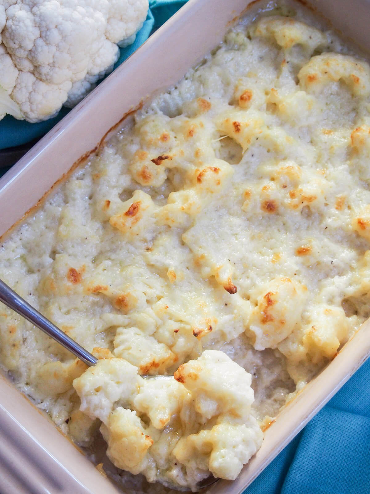 Cauliflower cheese is a classic British side dish that pairs perfectly with a roast, but also with a range of other dishes. It's easy, tasty and wonderfully comforting. spoon with some of cauliflower cheese scooped on it in dish