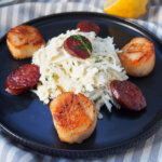 close view of plate of celeriac remoulade seared scallops and chorizo