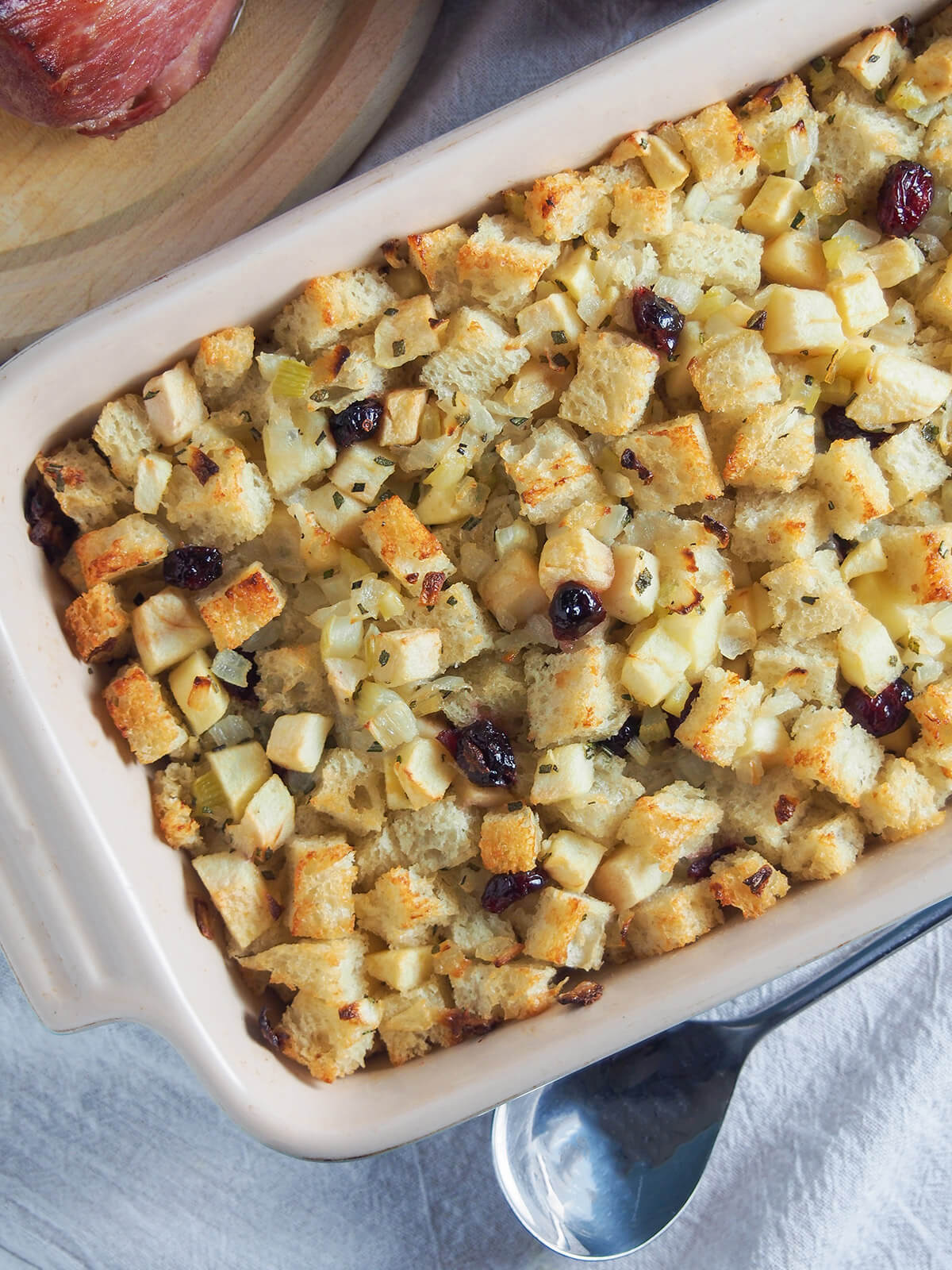 part view of dish of cranberry apple stuffing from overhead with spoon below
