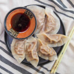 plate of cumin lamb dumplings with dipping sauce to top of plate