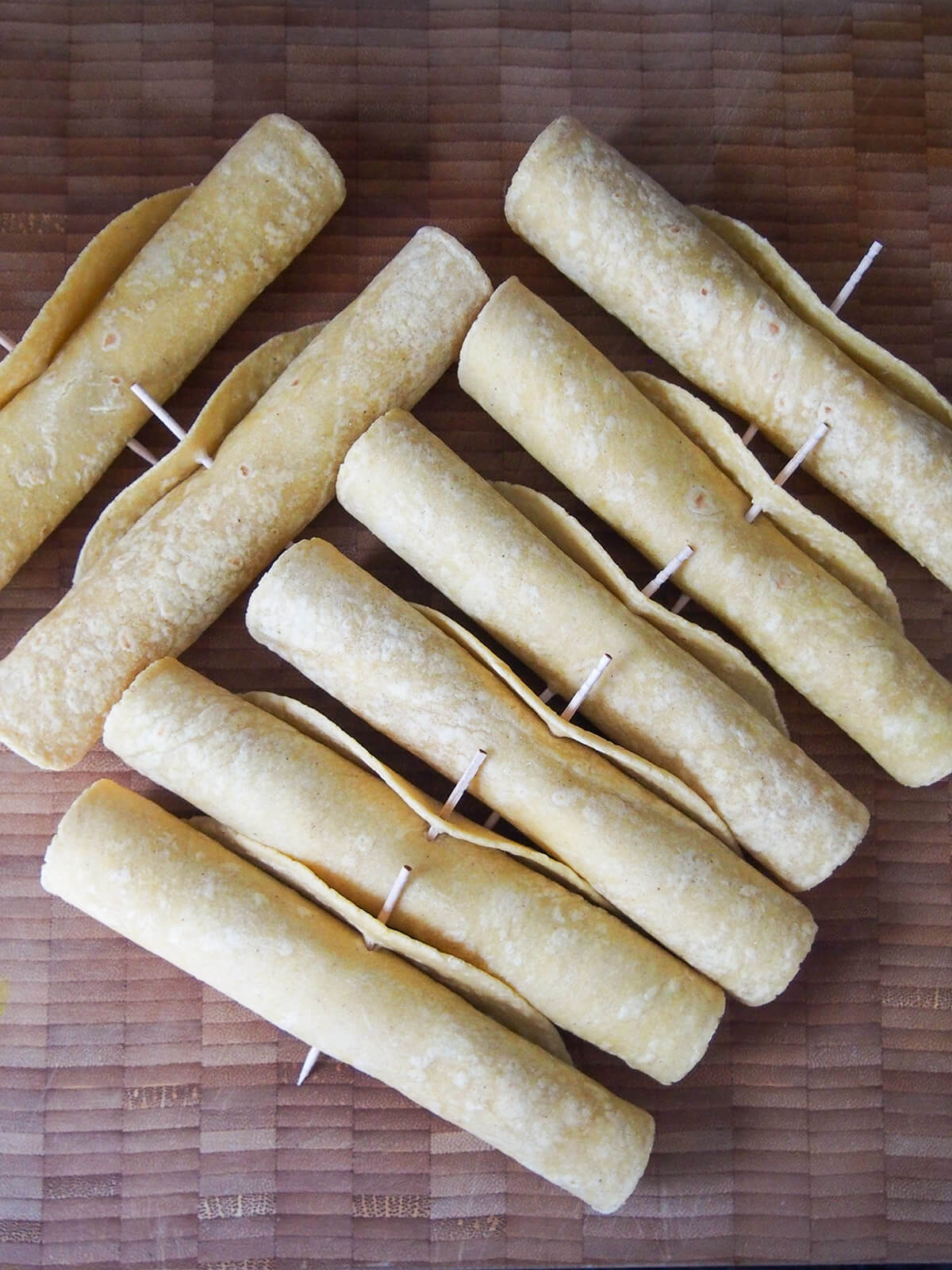 rolled chicken flautas held together with cocktail sticks before cooking