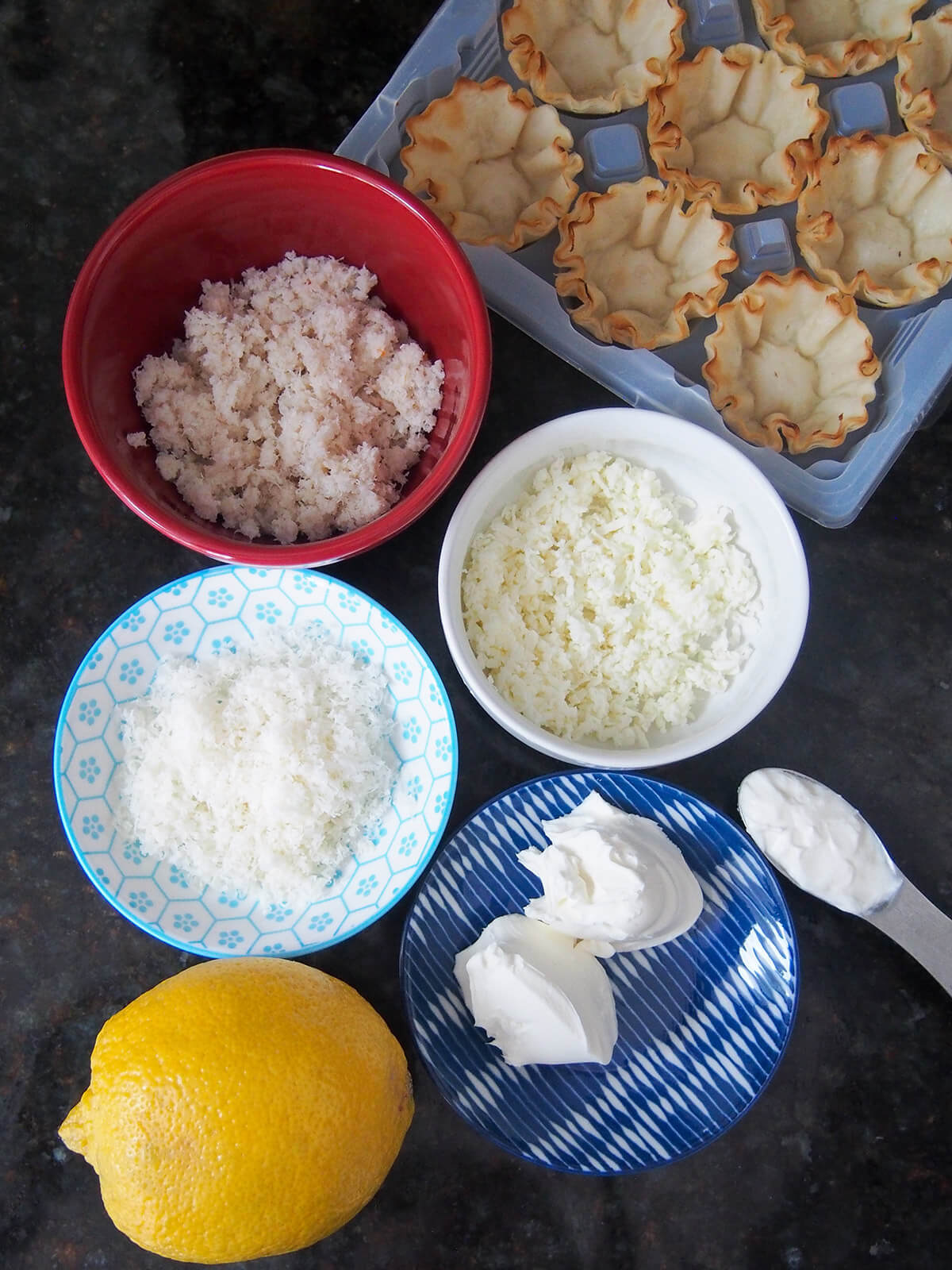 bowls with crab, mozzarella, parmesan, cream cheese with phyllo cubs above and lemon below