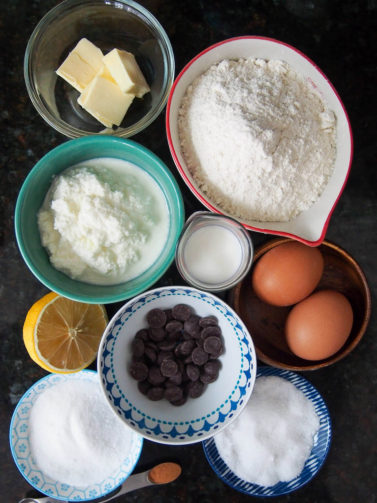 bowls with flour, ricotta, chocolate, eggs, butter, sugar, milk and lemon