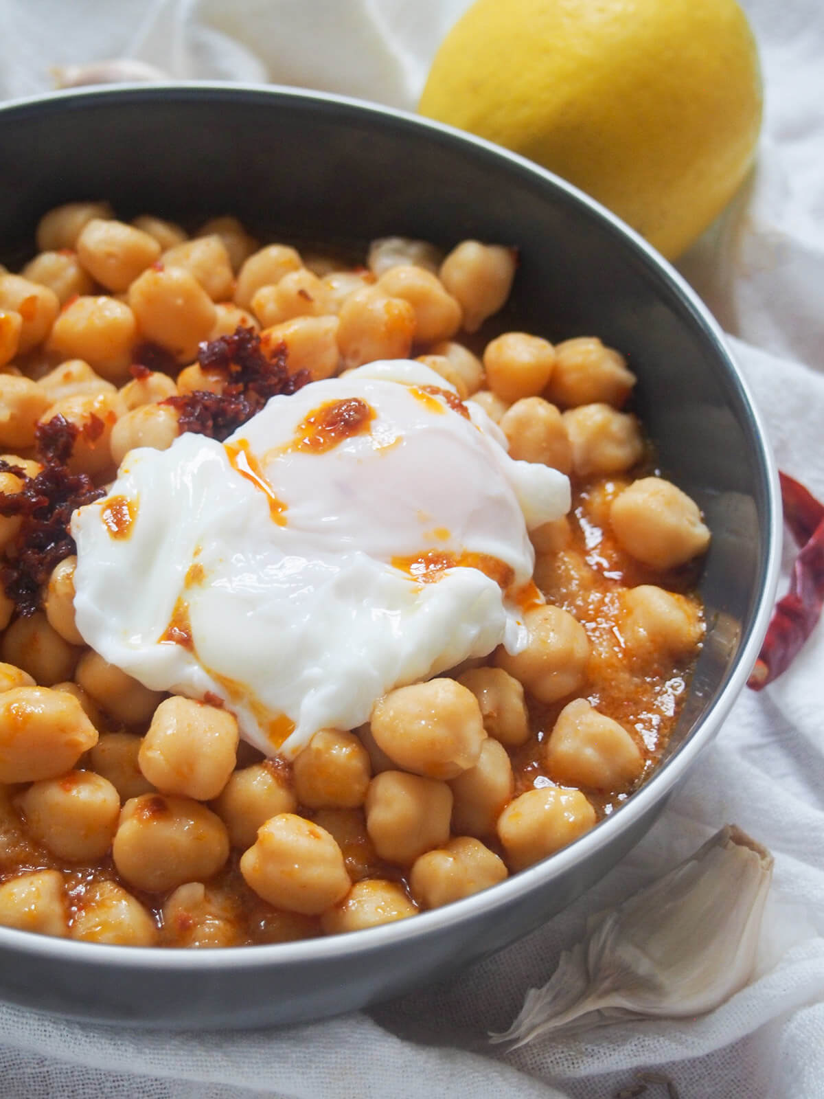 side view of bowl of lablabi Tunisian chickpea stew topped with an egg