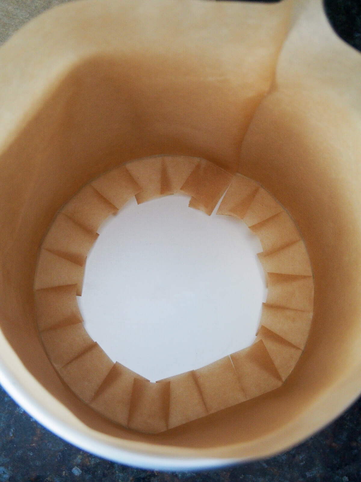 tall tin lined with parchment showing base in middle