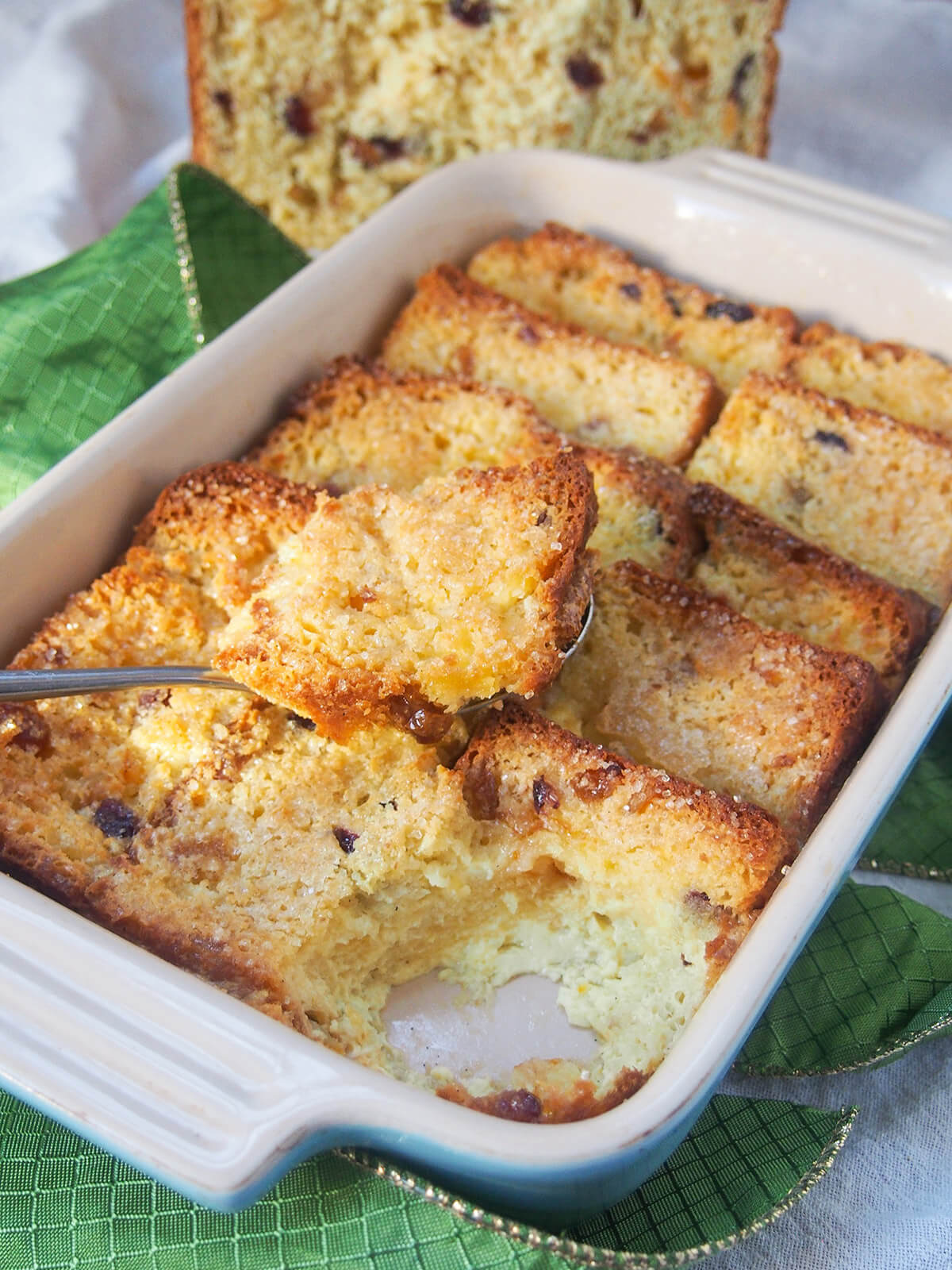spoon of panettone bread and butter pudding sitting on top of rest in dish