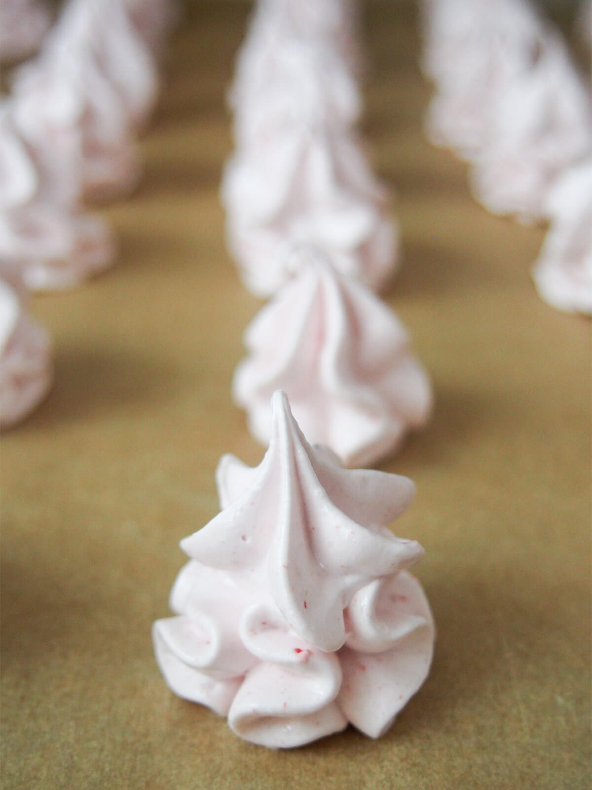 strawberry meringue cookies piped on parchment before baking