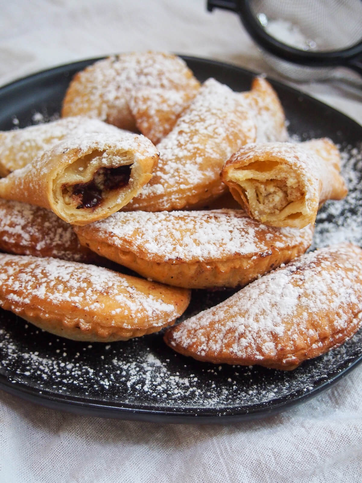 plate of ravioli dolci (sweet ravioli) with two open sitting on top showing creamy filling and chocolate