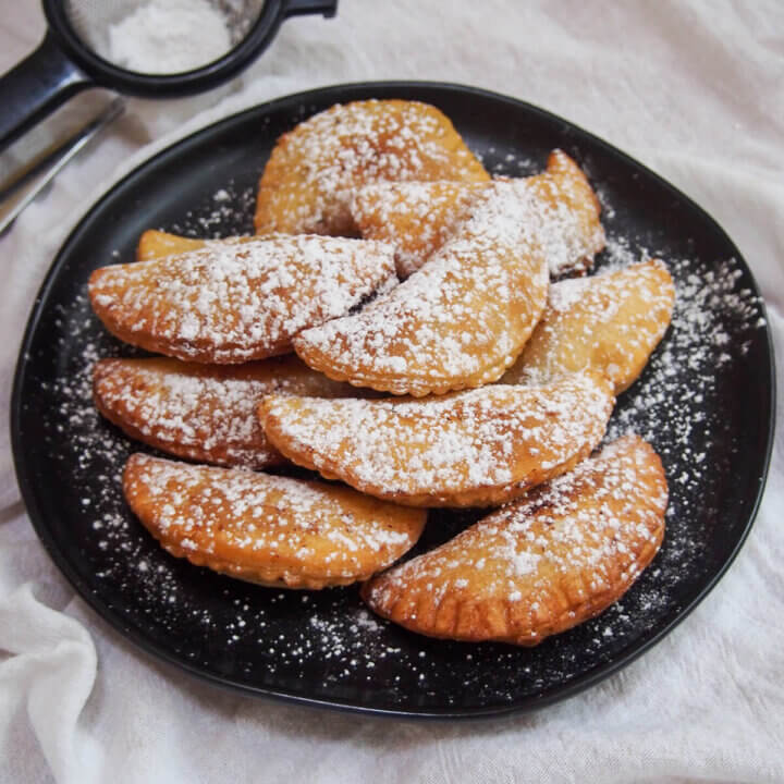 plate of ravioli dolci (sweet ravioli) dusted with powdered sugar