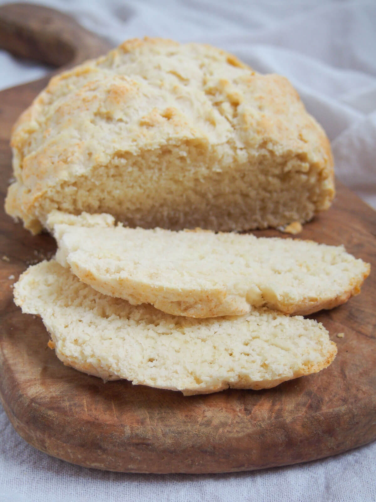 Australian damper is a type of quick bread that's really easy to make. Traditionally cooked in the fire, it's just as easy at home. Great with sweet or savory toppings. slices of damper bread in front of rest of loaf