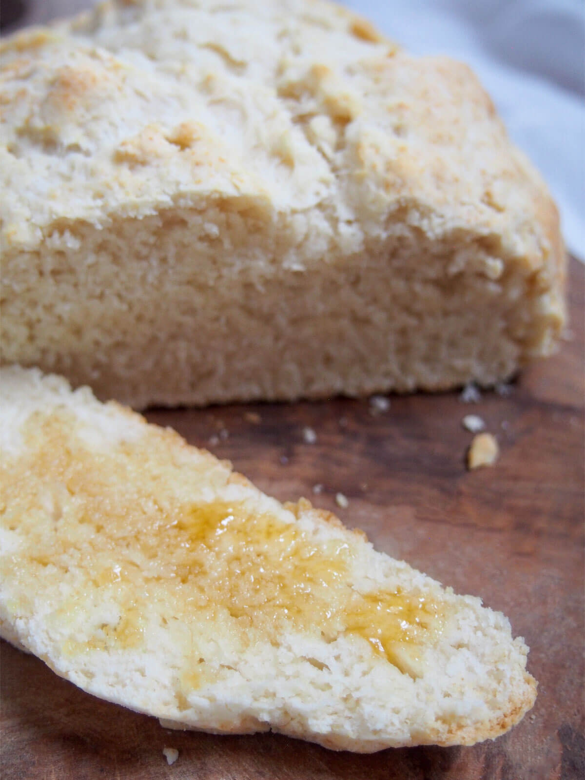 Australian damper is a type of quick bread that's really easy to make. Traditionally cooked in the fire, it's just as easy at home. Great with sweet or savory toppings. slice of damper topped with golden syrup