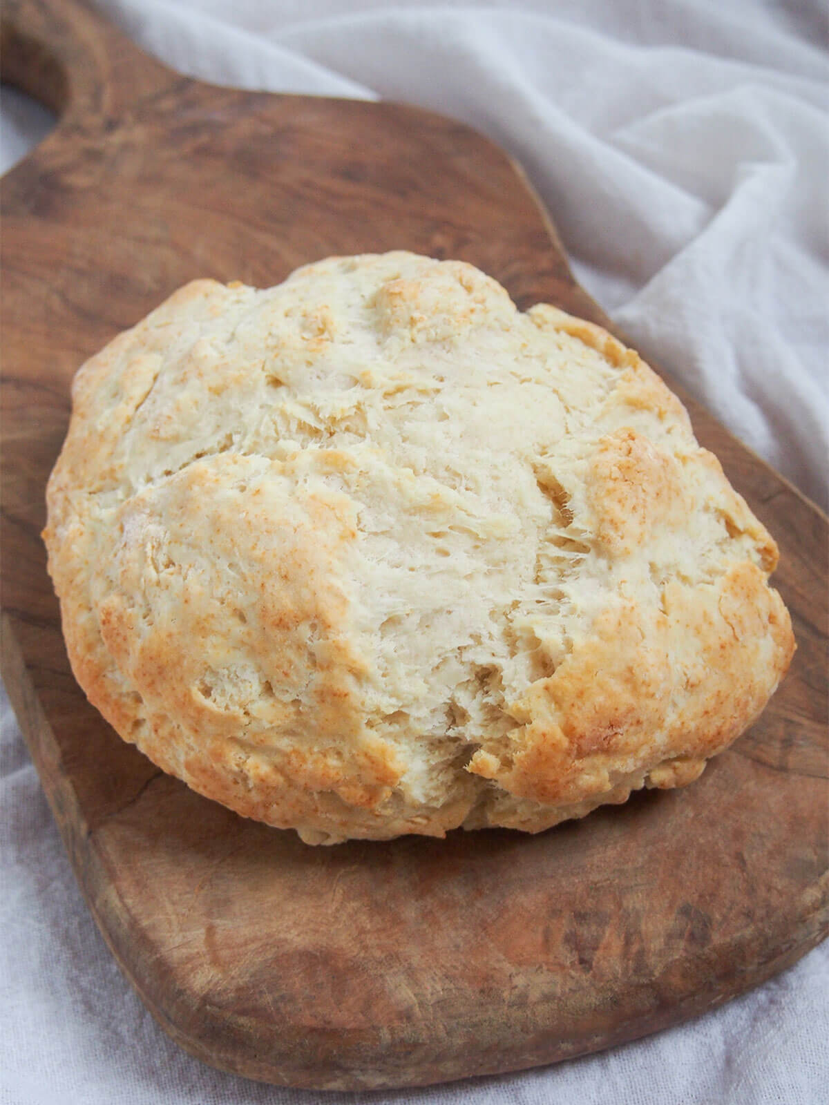 Australian damper is a type of soda bread that's really quick & easy to make. Traditionally cooked in the fire, it's just as easy at home. Great with sweet or savory toppings. whole loaf of Australian damper bread on board