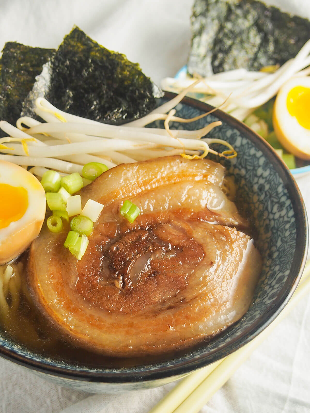 close view of chashu pork on top of bowl of ramen