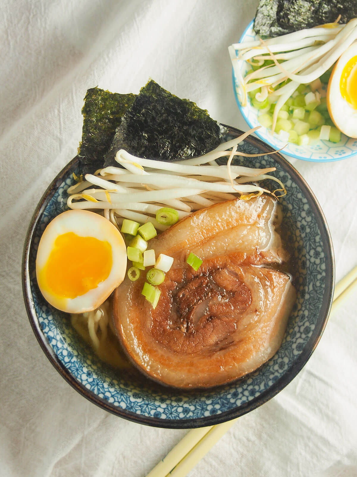 overhead view of bowl of chashu pork ramen, with pork, egg and beansprouts on top