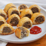plate with haggis sausage rolls with one at front bitten into