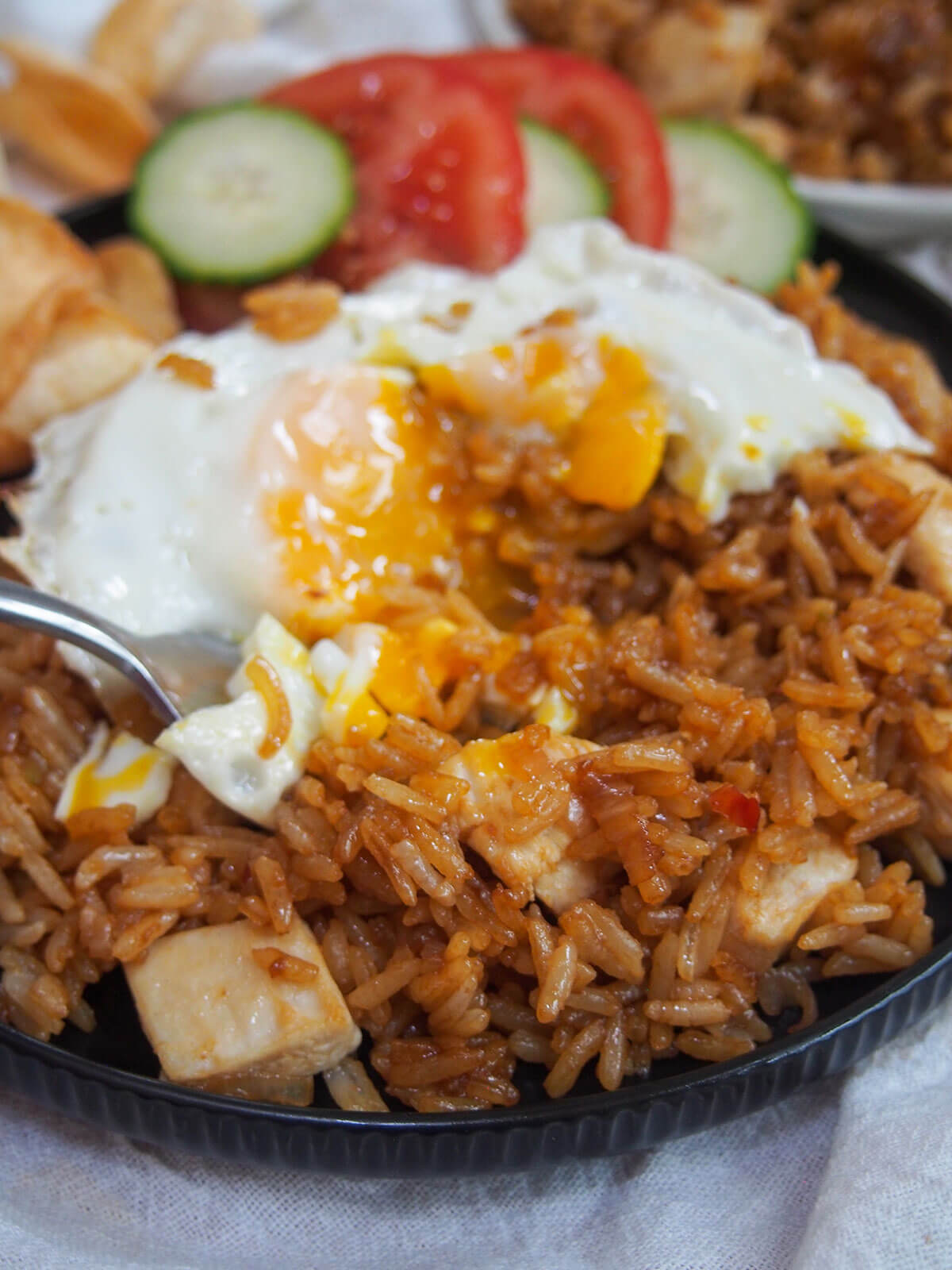 taking a forkful of rice and egg, with yolk oozing into rice behind