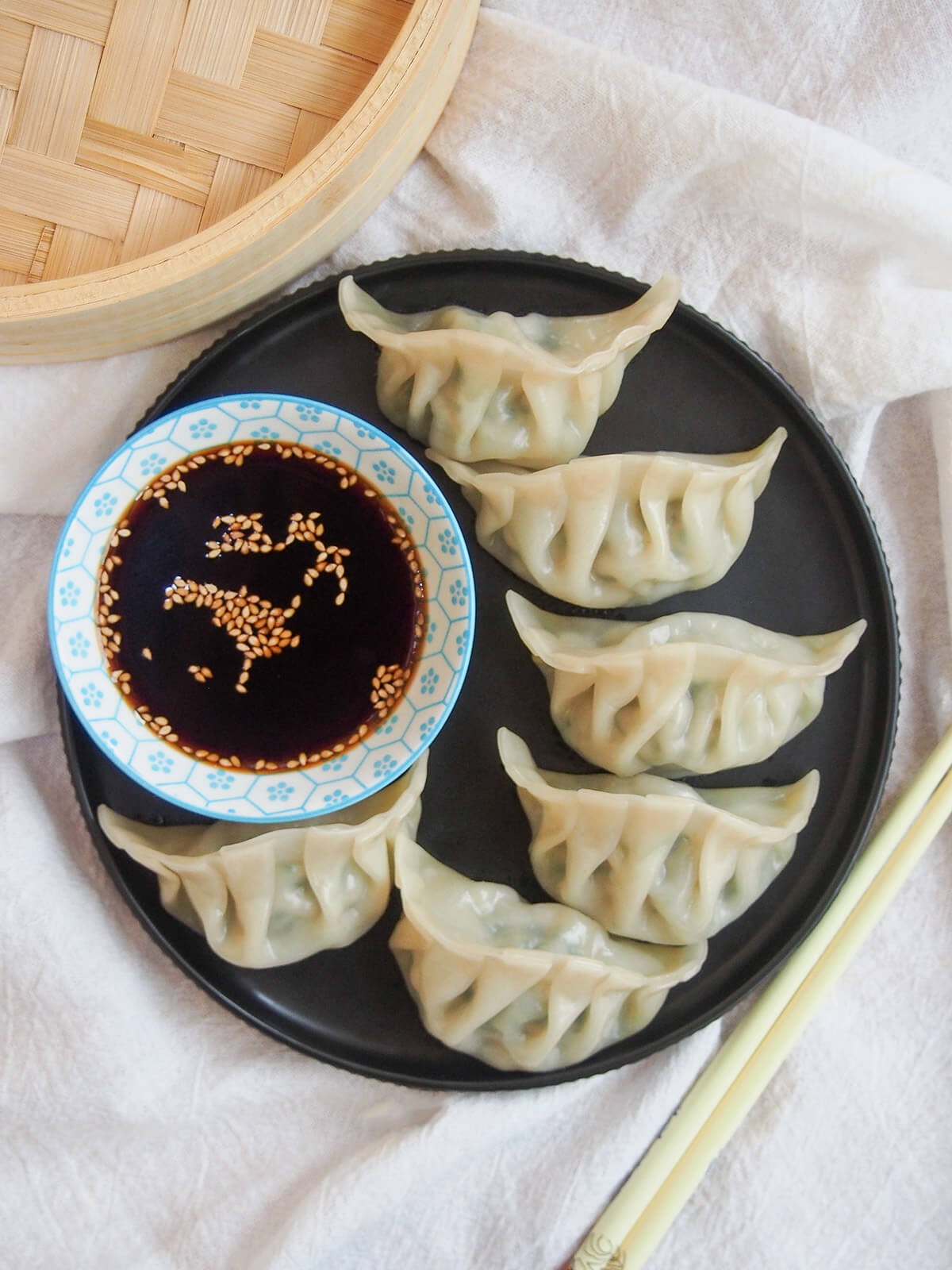Pork and chive dumplings are a classic Chinese jiaozi - it's a simple, delicious combination balancing rich pork and bright herbs. Easy to make and so tasty. overhead view of plate of pork and chive dumplings