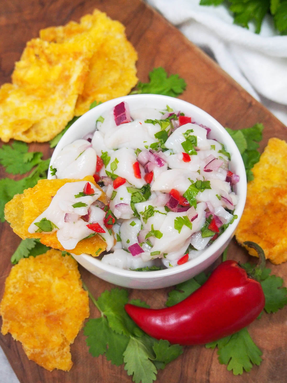 overhead view of scallop ceviche with plantain chip on side of bowl