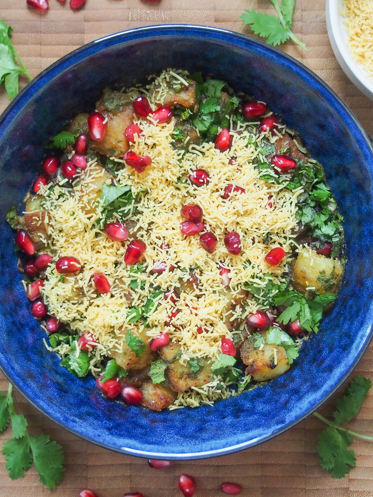Aloo chaat is a delicious Indian snack combining fried potatoes with spices, chutney, herbs and more. It's easy to make, has tangy and spicy flavors and is addictively good. bowl of aloo chaat from overhead