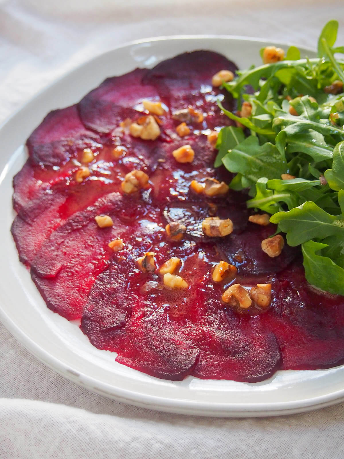 side view of slices of beet carpaccio on plate