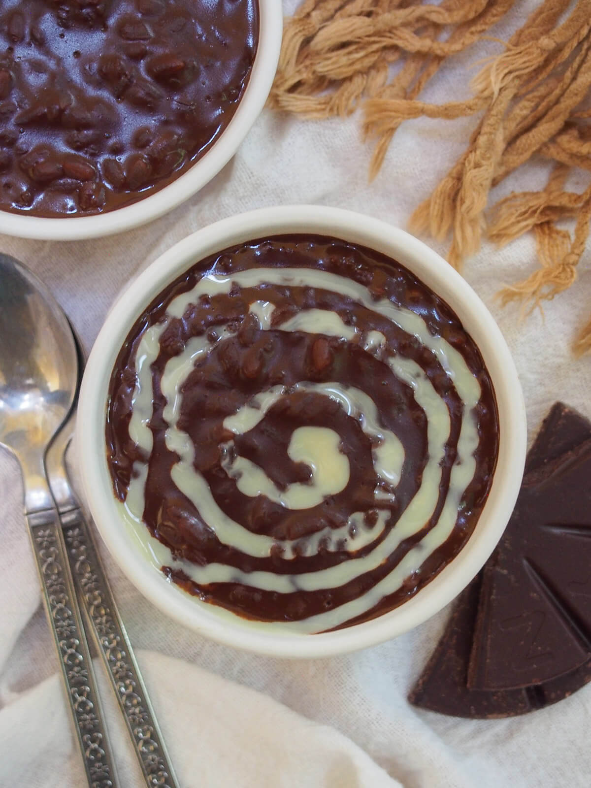 overhead view of bowl of champorado - Filipino chocolate rice porridge - topped with drizzle of condensed milk