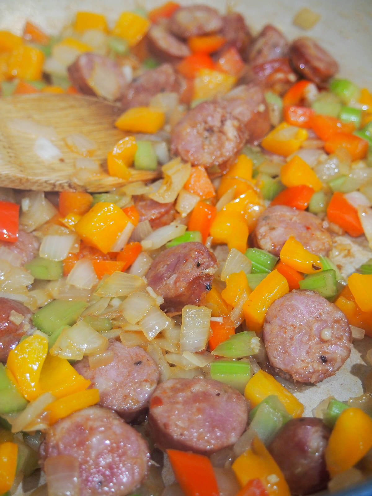 cooking onion, pepper, celery and Andouille sausage