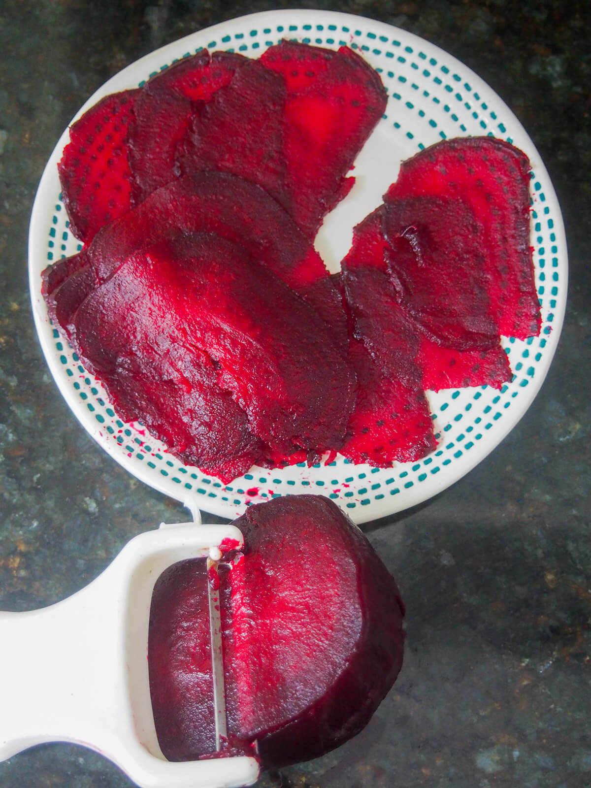 slicing beet with vegetable peeler with thin slices on pate