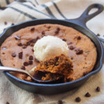 spoon at front of mini skillet cookie with scoop of cookie on it