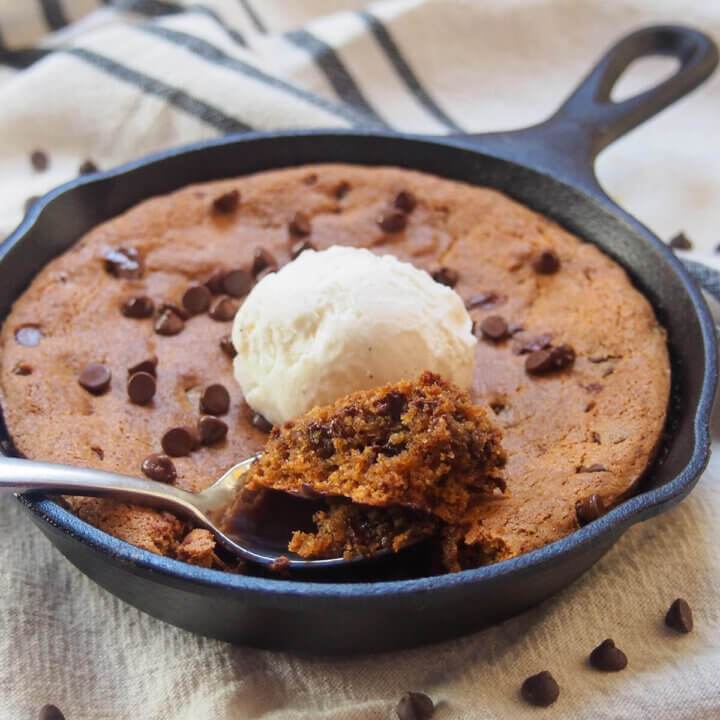 spoon at front of mini skillet cookie with scoop of cookie on it