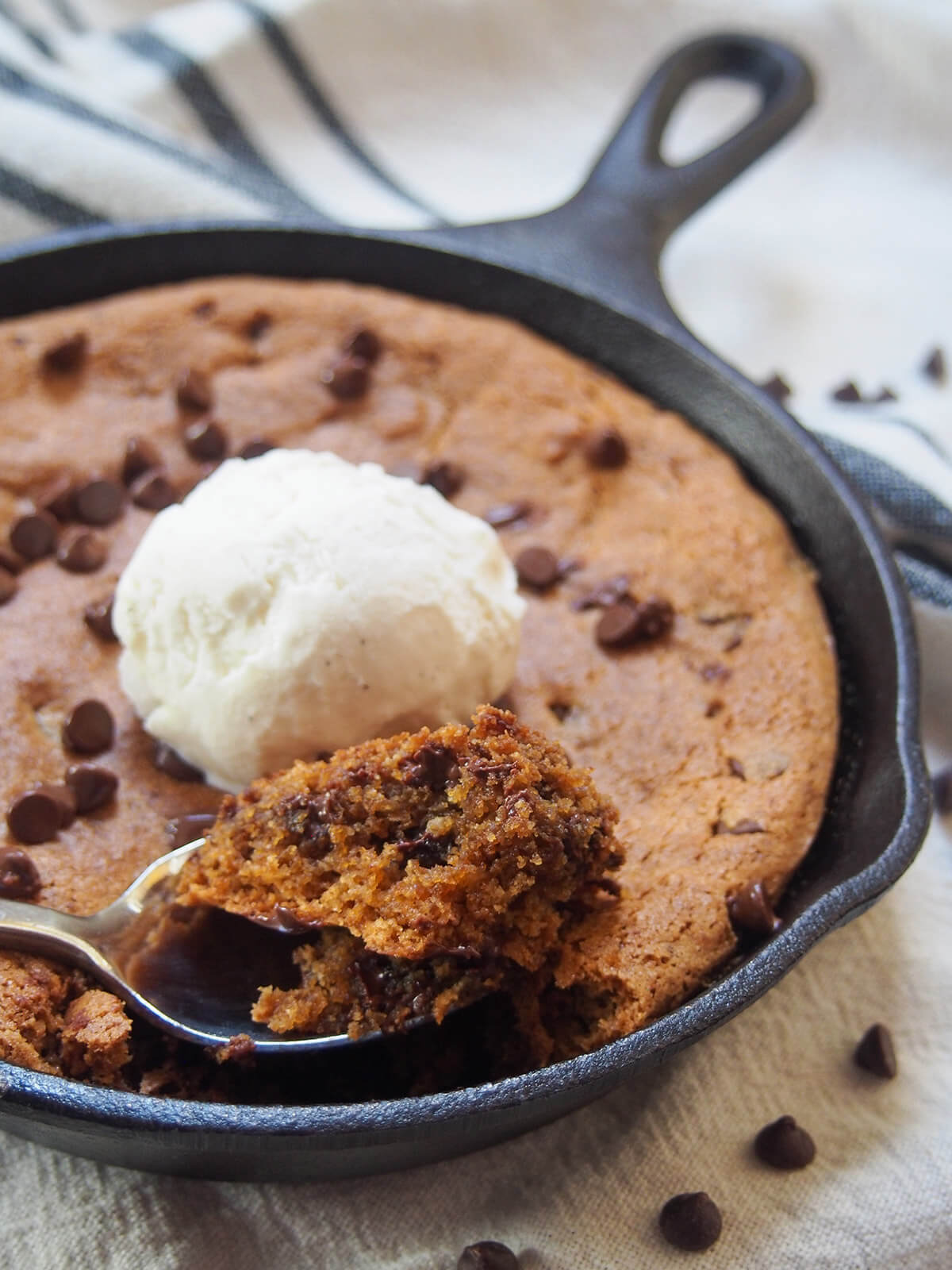 close view of mini skillet cookie with spoonful of cookie sitting at front