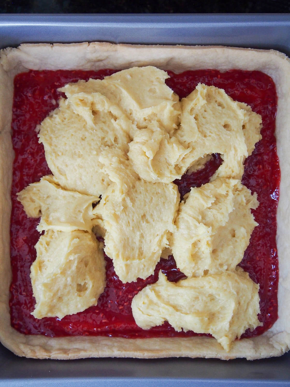 dotted topping on top of jam layer in pastry base