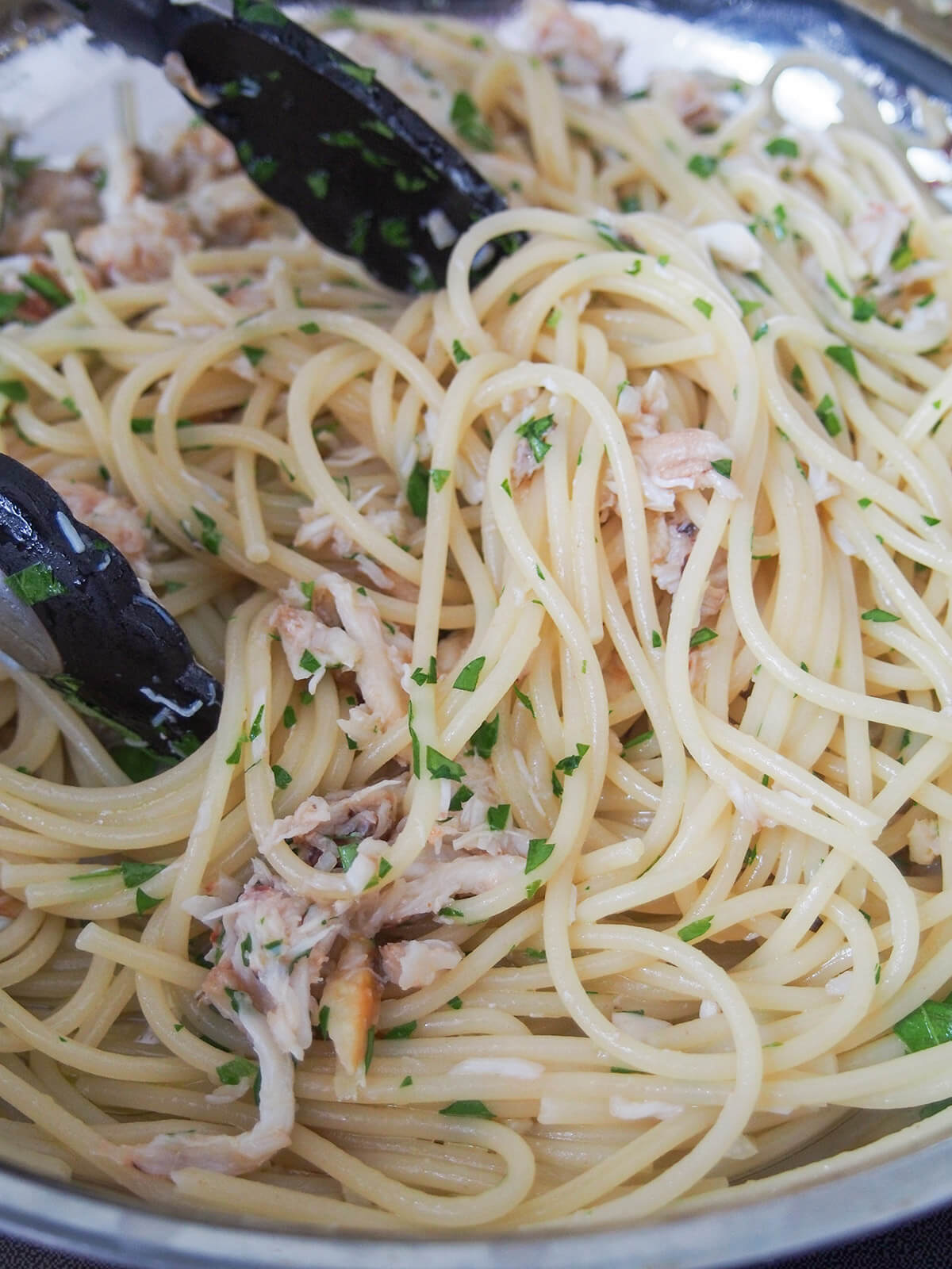 mixing crab and parsley into pasta