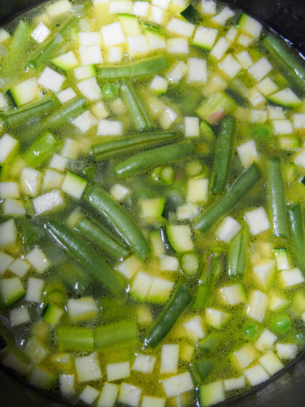 making minestrone primavera vegetables in broth