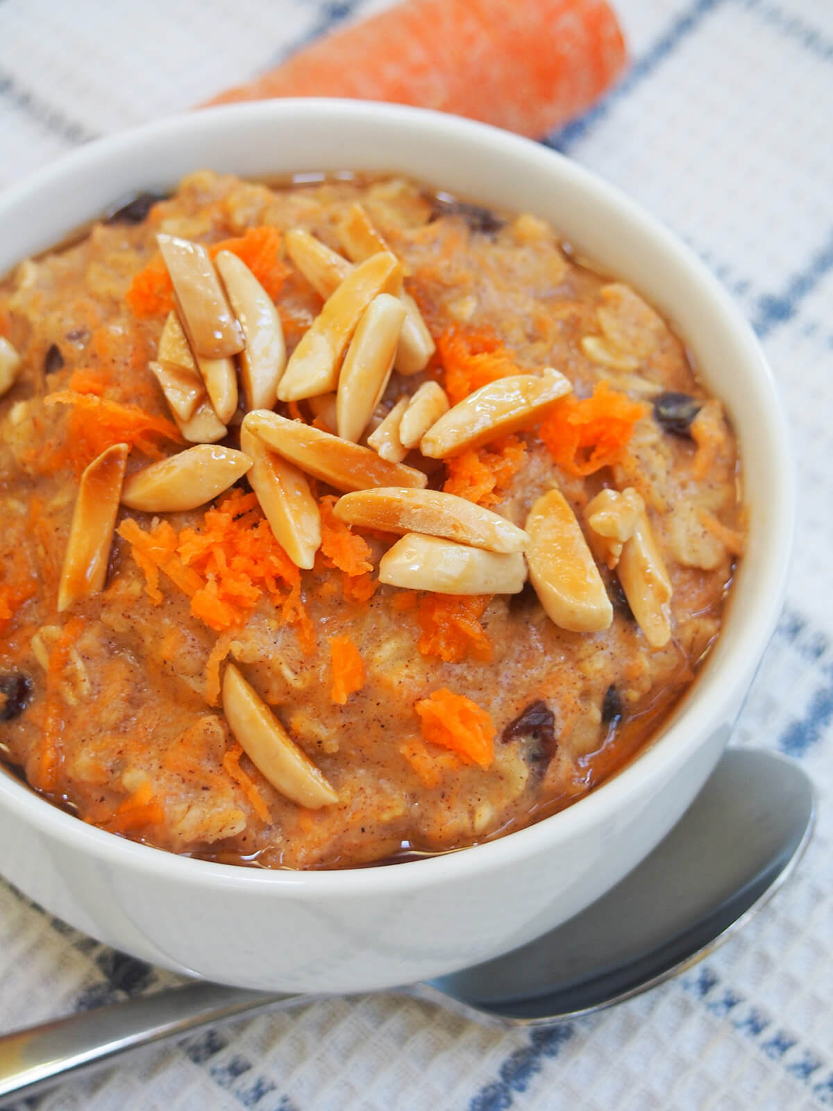 side view of carrot cake oatmeal with spoon below bowl