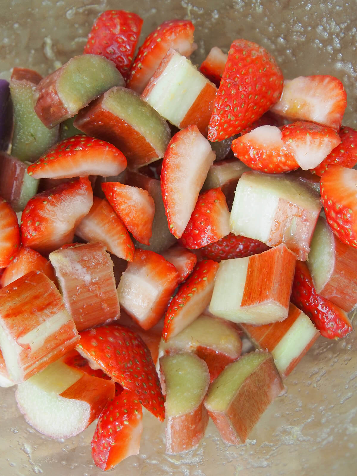 fruit for strawberry rhubarb crisp chopped rhubarb and strawberry chunks in a bowl with a little sugar stuck on side