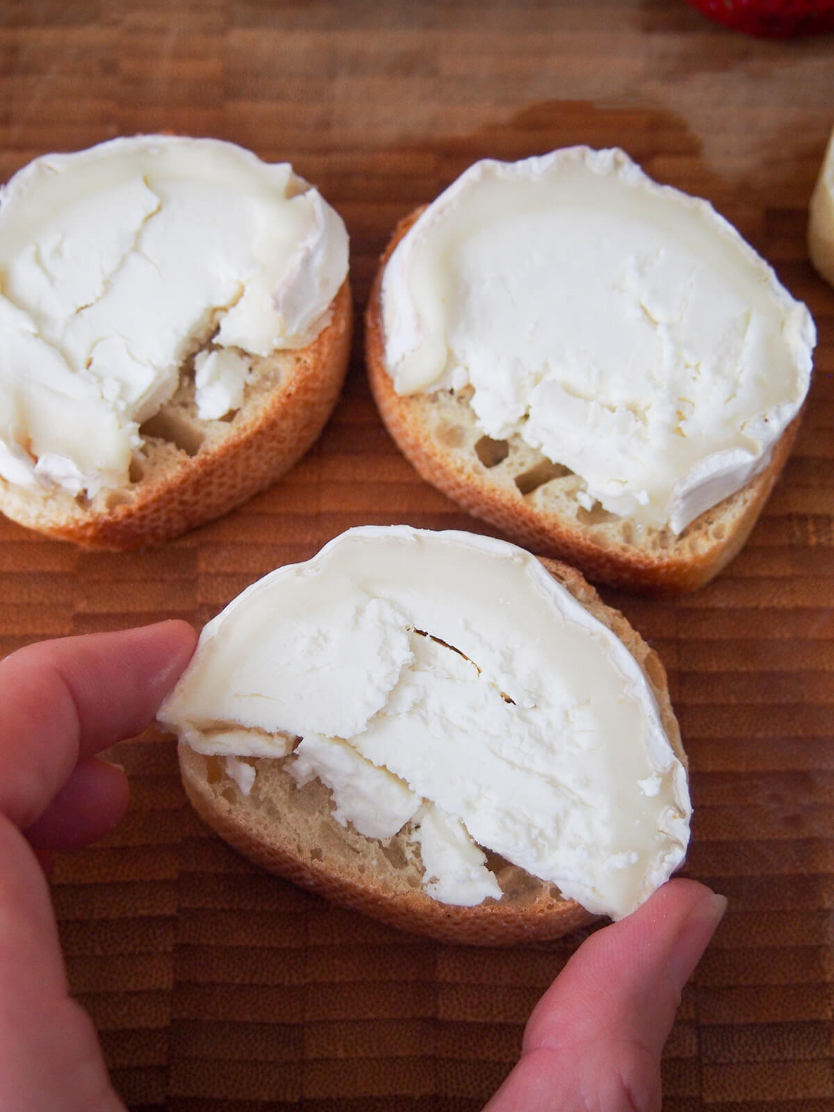 pressing goat cheese onto slices of bread fro goat cheese toasts