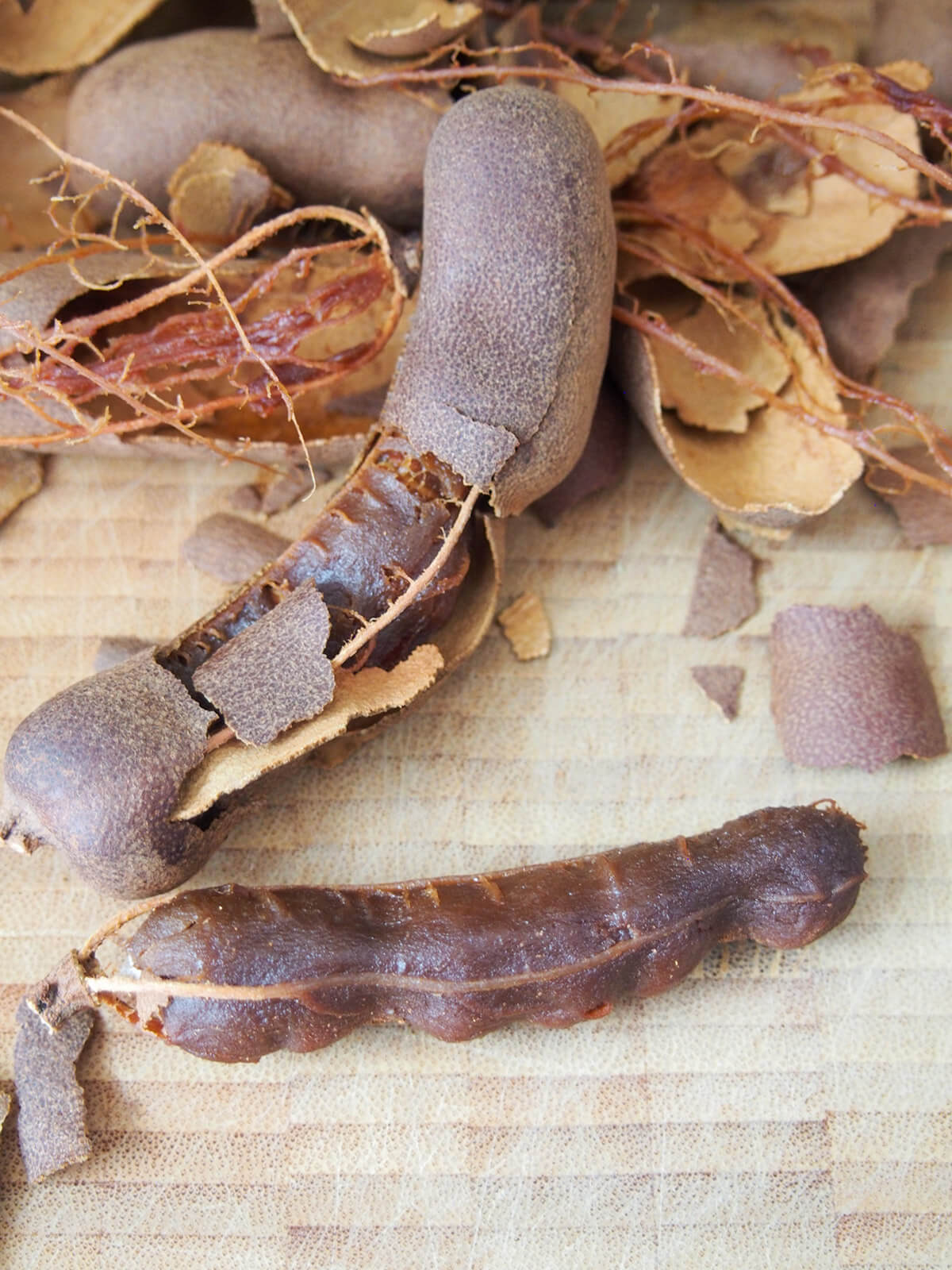 peeling shell from tamarind pods