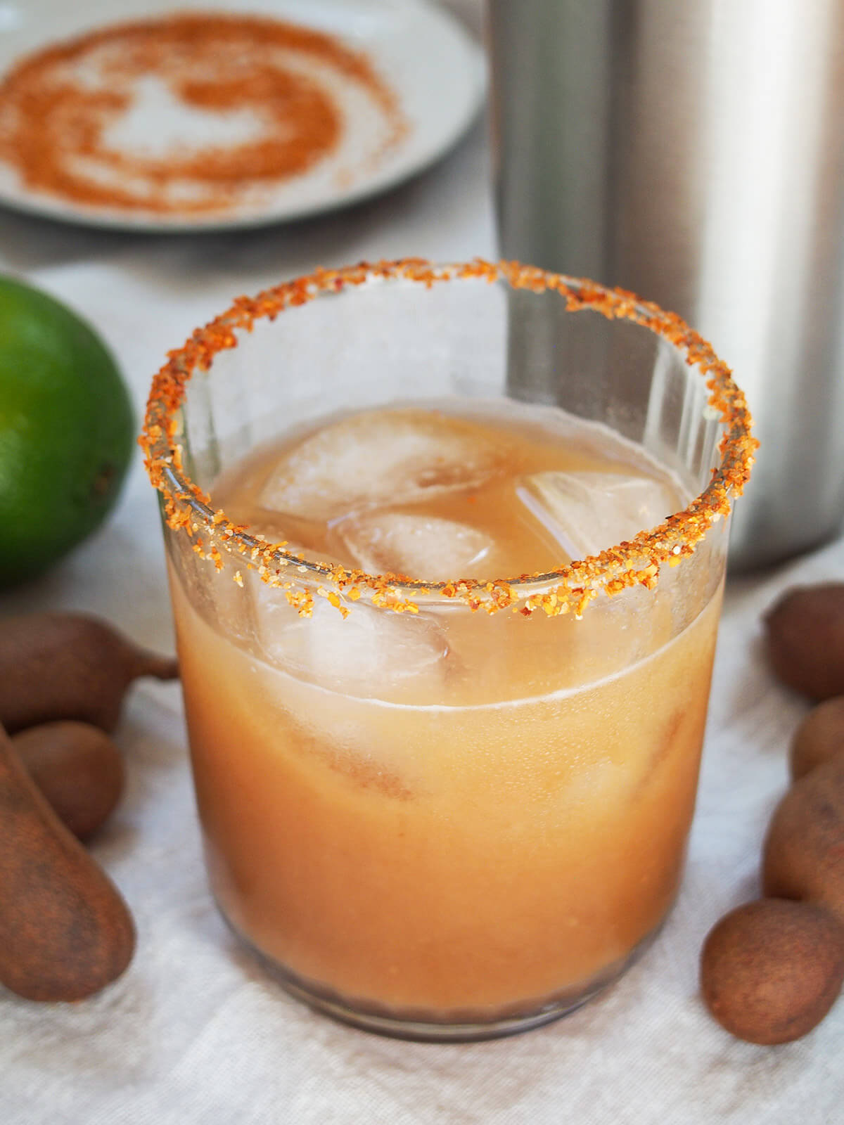 glass of tamarind margarita with shaker behind