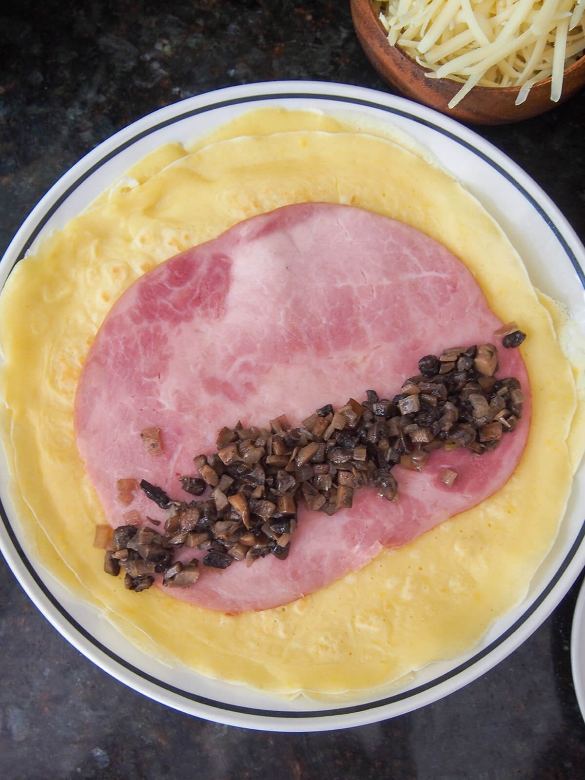 mushroom duxelle on slice of ham on top of a crepe with cheese in corner